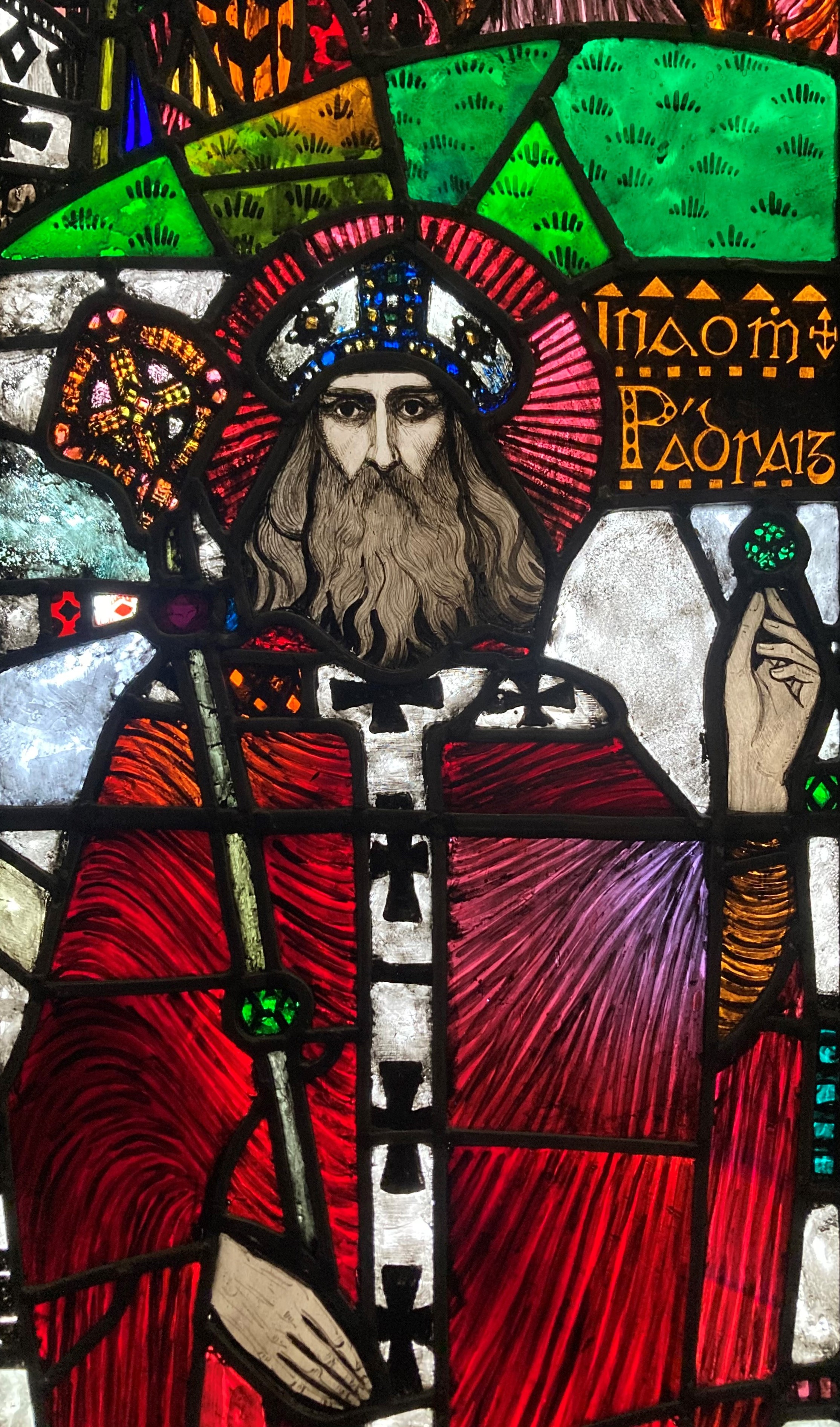 Stained glass panel depicting St Patrick holding a shamrock, by Michael Healy