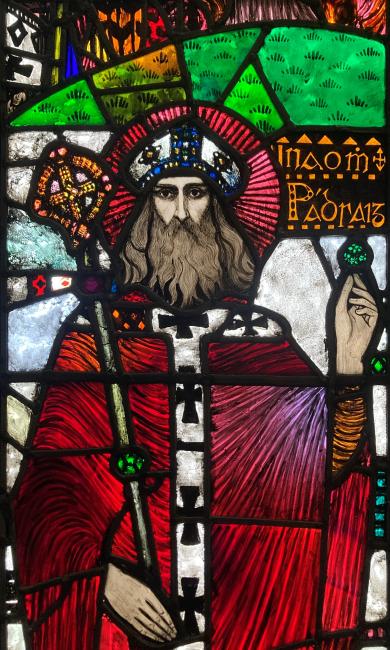 Stained glass panel depicting St Patrick holding a shamrock, by Michael Healy